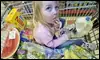 Una niña prueba la comida en el carrito de la compra que empujan sus padres en un supermercado de Danvers (EE.UU.) / AP