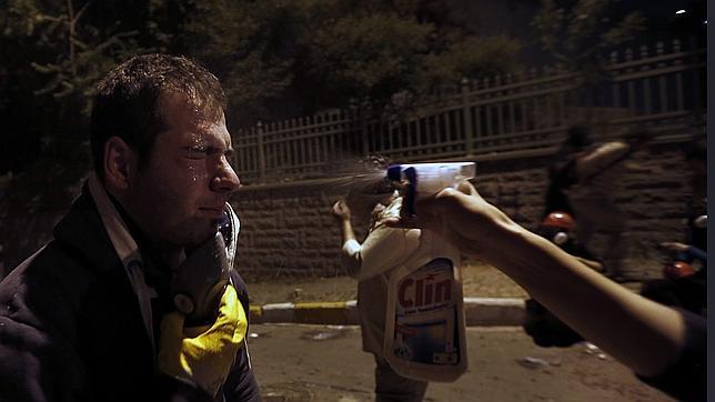 Un manifestante se echa una solución para reducir los efectos de los gases lacrimógenos empleados por la agresiva policía turca