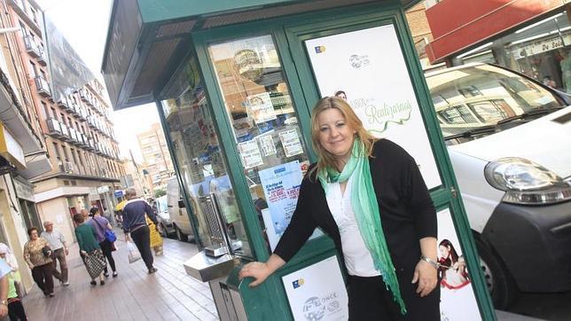 Pilar posa en el quiosco de la ONCE de Móstoles en el que trabaja