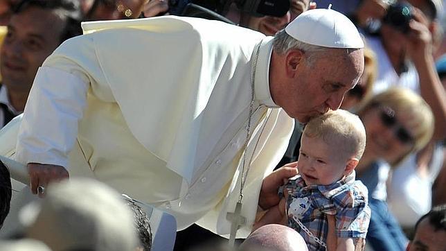 El Papa Francisco besa a un niño durante una audiencia general celebrada en la Plaza de San Pedro