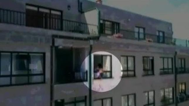 Una madre zarandea a su bebé por fuera de una ventana amenazando con tirarlo