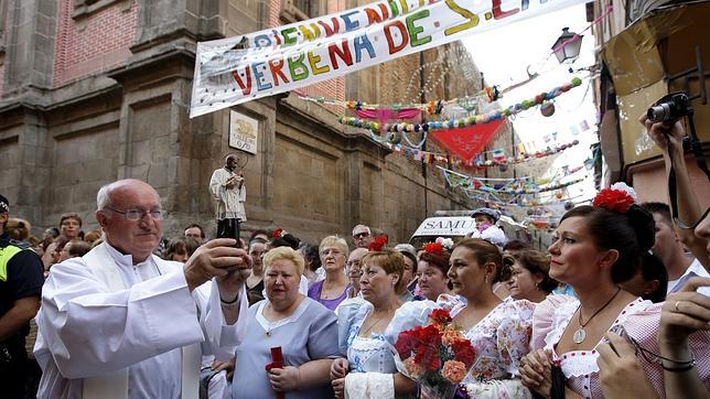 Un sacerdote muestra una imagen de San Cayetano