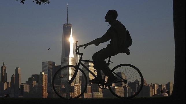 Un hombre pedalea en Nueva Jersey. A su derecha, se puede observar el «skyline» de Manhattan