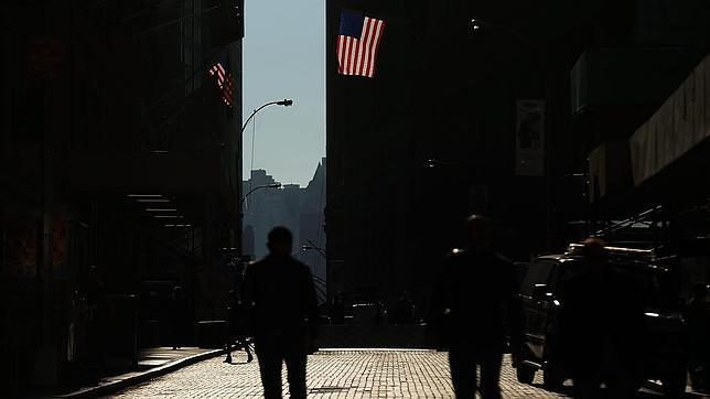 Tres hombres caminan por una calle del distrito financiero de Nueva York