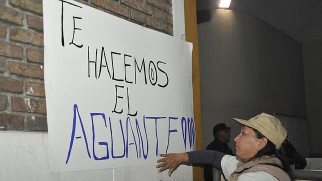 Seguidores de la presidenta argentina pegan pancartas de apoyo en el hospital donde pasará por el quirófano