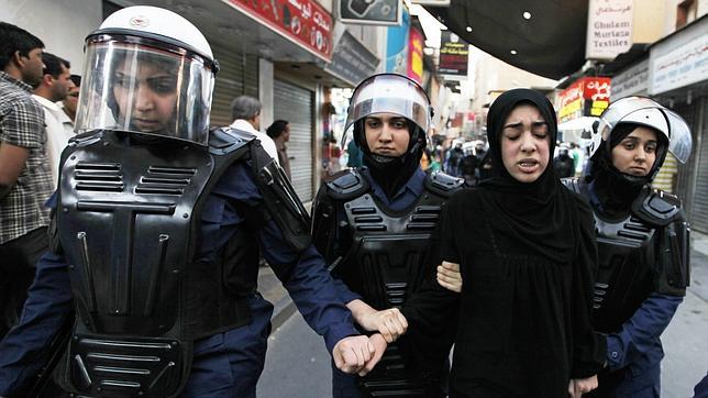 Mujeres policía detienen a una manifestante