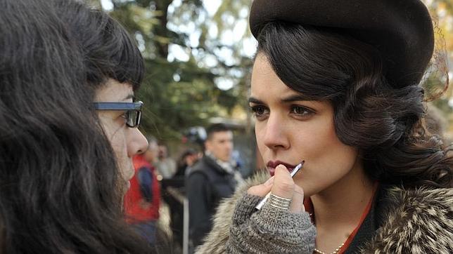 Una maquilladora retoca el maquillaje a Adriana Ugarte durante un rodaje en exteriores