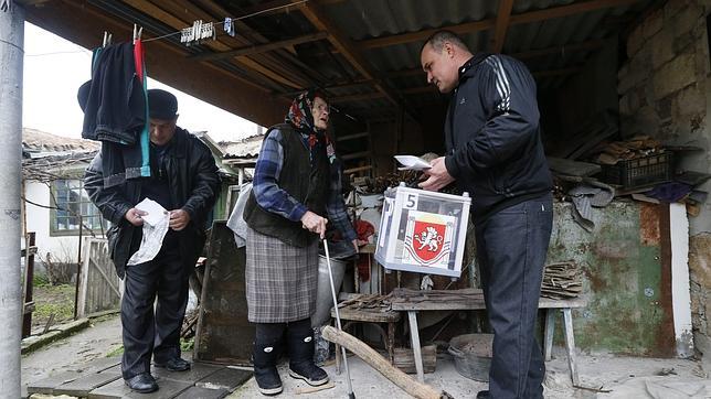 Autoridades electorales atienden a una anciana en Belogorsk, a las afueras de Simferópoli