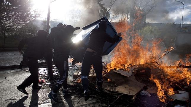Radicales levantan una barricada de contenedores quemados