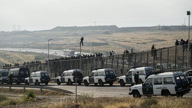 Los inmigrantes encaramados a la valla de Melilla se bajan tras seis horas