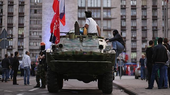 Rebeldes prorrusos en un blindado, junto a una sede regional en Donetsk (este de Ucrania)