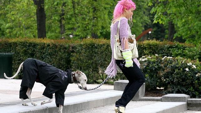 Un perro pasea con su dueña por el parque de El Retiro de Madrid