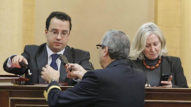 Un Ujier entrega equipos de traducciónsimultanea a miembros de la mesa