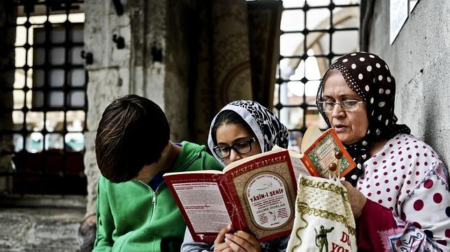 Una mujer y sus nietos leen el Corán en Estambul, Turquía