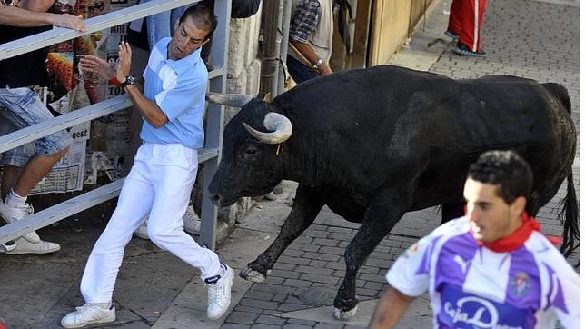 Aficionado intentando esquivar a un toro