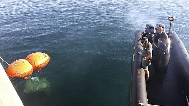 La Guardia Civil observa el bloque reflotado por la Fundación de Defensa Nacional Española (Denaes)