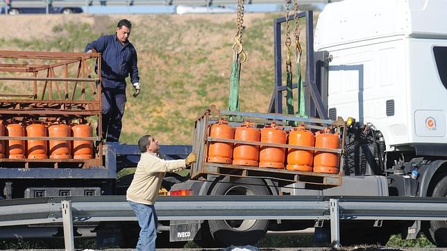 Dos personas cargan y descargan las bombonas de butano de un cambión