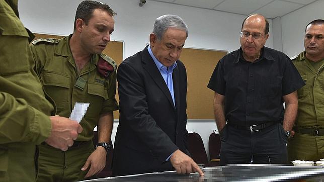 El primer ministro israelí, Benjamín Netanyahu (c), y al ministro de Defensa israelí, Moshe Yaalon (2d), durante su visita al Comando Sur del ejército israelí, en una localización no facilitada de Israel