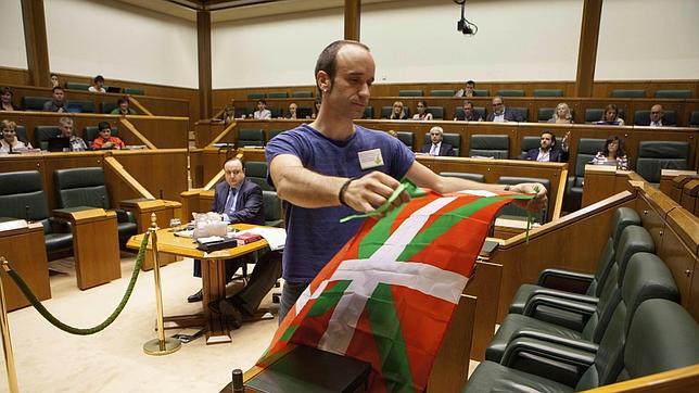 Iñaki Lazarobaster deposita una ikurriña en el escaño en el Parlamento Vasco el Iñigo Urkullu