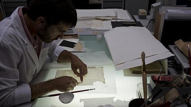 Un trabajador de la Biblioteca, trabajando en la recuperación de un documento