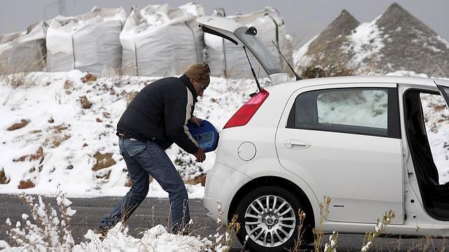 Un conductor se disponea colocar las cadenas en su coche en una carretera cercana almunicipio castellonense de Viver