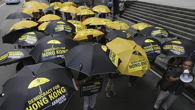 Varios filipinos se manifiestan con paraguas para mostrar su apoyo a los manifestantes prodemocráticos hongkoneses delante del Consulado de China en la ciudad de Makati, sur de Manila