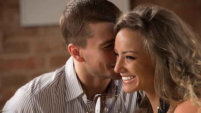 Un hombre susurrrándole a una mujer