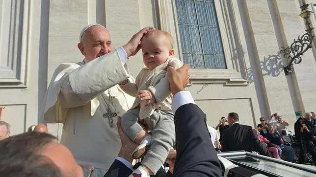 El Papa Francisco bendice a un niño a su llegada a la audiencia general en la plaza de San Pedro del Vaticano