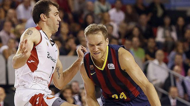 El escolta estadounidense del FC barcelona Brad Oleson (d) avanza con el balón ante la defensa del estadounidense Benjamin Dewar, alero de La Bruixa d'Or