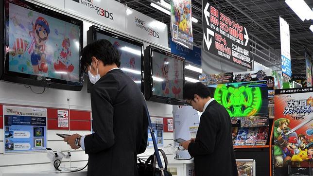 Varios consumidores prueban juegos de Nintendo en una tienda en Tokyo
