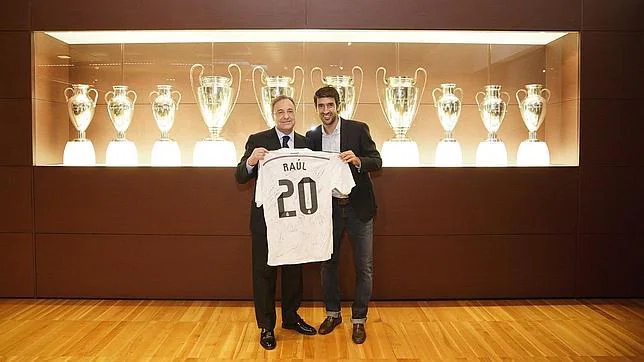 Raúl y Florentino Pérez muestran la camiseta firmada por todos los jugadores en homenaje a su ex compañero