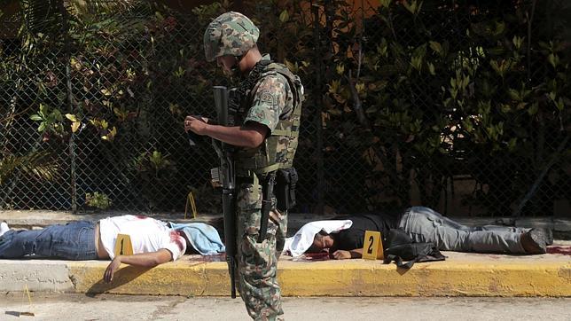 Un militar junto a dos cadáveres en Acapulco, Guerrero, uno de los estados más azotados por la violencia en México
