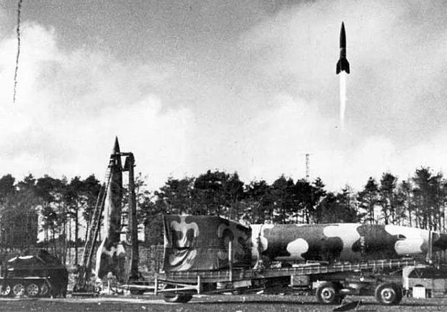 Varios misiles V-2 en distintas fases para su lanzamiento. En primer plano, un misil recién llegado a la base, otro preparado en su lanzadera móvil (camiones especialmente equipados) y un tercero en el momento de despegar