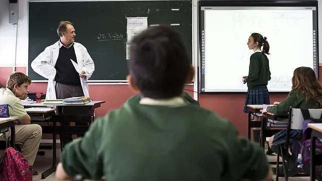 Un profesor examina oralmente a un alumna del colegio Los Sauces (Madrid)