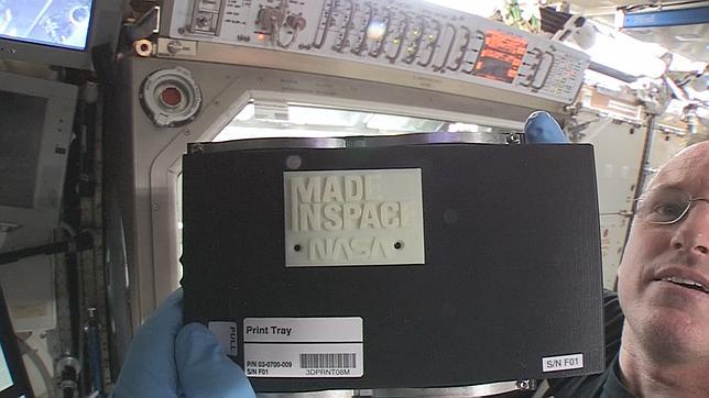 El comandante de la ISS Barry «Butch» sostiene el primer objeto hecho por una impresora 3D en el espacio
