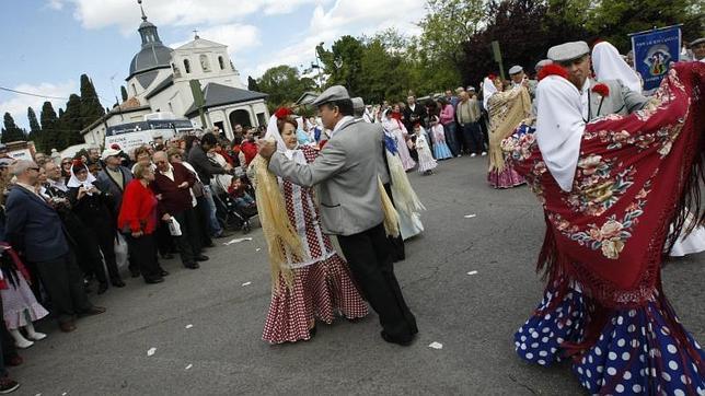 Varias parejas de chulapos bailan chotis el día de San Isidro en la ermita del santo