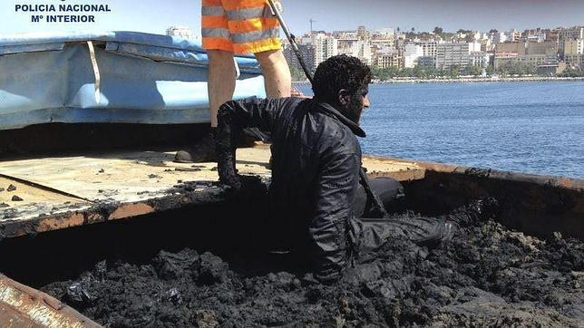 Un inmigrante escondido en una embarcación llena de fango intenta entrar en la carga de un mercante en 2013
