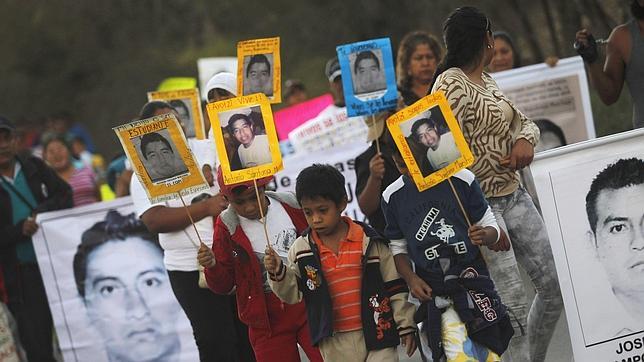 Menores con las fotos de los desaparecidos de la Escula Normal de Ayotzinapa