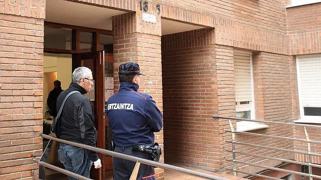 Agentes de la Ertzaintza en el portal de la vivienda de la localidad vizcaína de Abadiño donde una mujer y su madre han sido halladas muertas y ensangrentadas en su vivienda