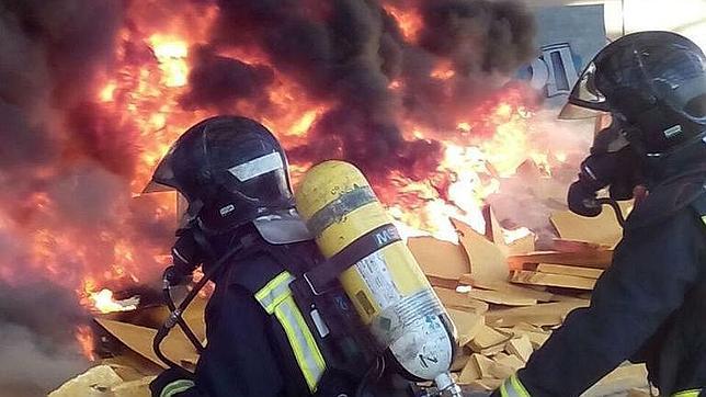 Los bomberos apagando las llamas en las ruinas de la fábrica de Dhul