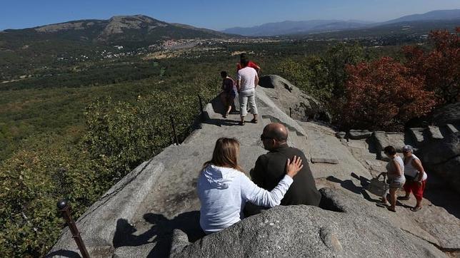 Varios visitantes se sientan en la conocida como la «silla de Felipe II»