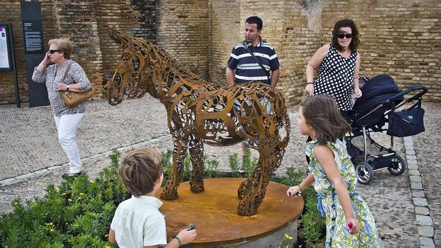 Platero y yo, homenajeado: una familia observa la nueva escultura del museo al aire libre "Platero Es-cultura", ubicada en la plaza de Las Monjas de Moguer (Huelva)