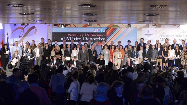 Foto de familia en la que la presidenta de Castilla-La Mancha posa con todos los premiados