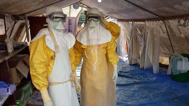Dos sanitarios de Médicos sin Fronteras se colocan los trajes de protección para tratar a pacientes con ébola en Conakry