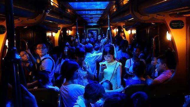 Esta es la foto ganadora del año, con el móvil iluminado en el centro de este vagón del metro de Hong Kong