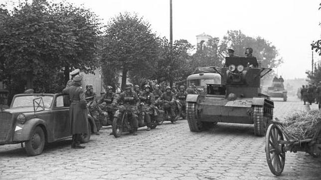 Tropas acorazadas del Ejército Rojo entran en una localidad polaca, pasando ante una unidad de motoristas de la Wehrmacht