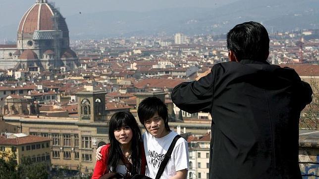 Dos turistas japoneses posan para una fotografía en Florencia (Italia)