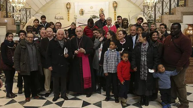 El arzobispo de Madrid, Carlos Osoro (c), bendice a las familias que se acercan a la catedral de la Almudena