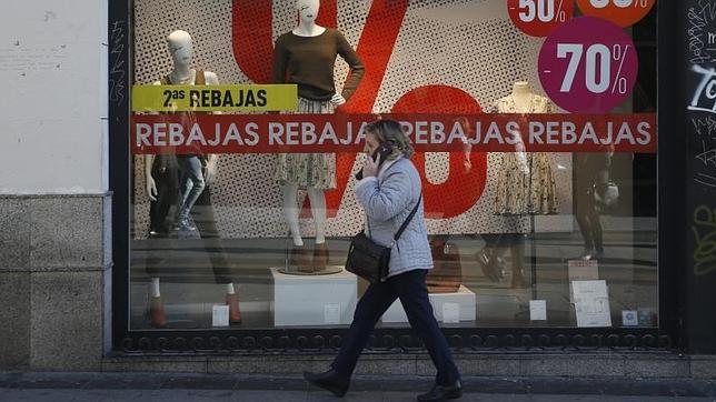 Una mujer pasea por la calle Preciados, ya con todos los carteles que anuncian las rebajas
