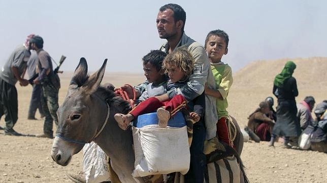 Refugiados cristianos y yasidies huyen hacia la frontera de Irak con Siria